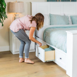 woman pulling out the storage underneath white tv lift bed