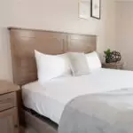 Headboard of a wood tv lift bed with wood nightstand next to it