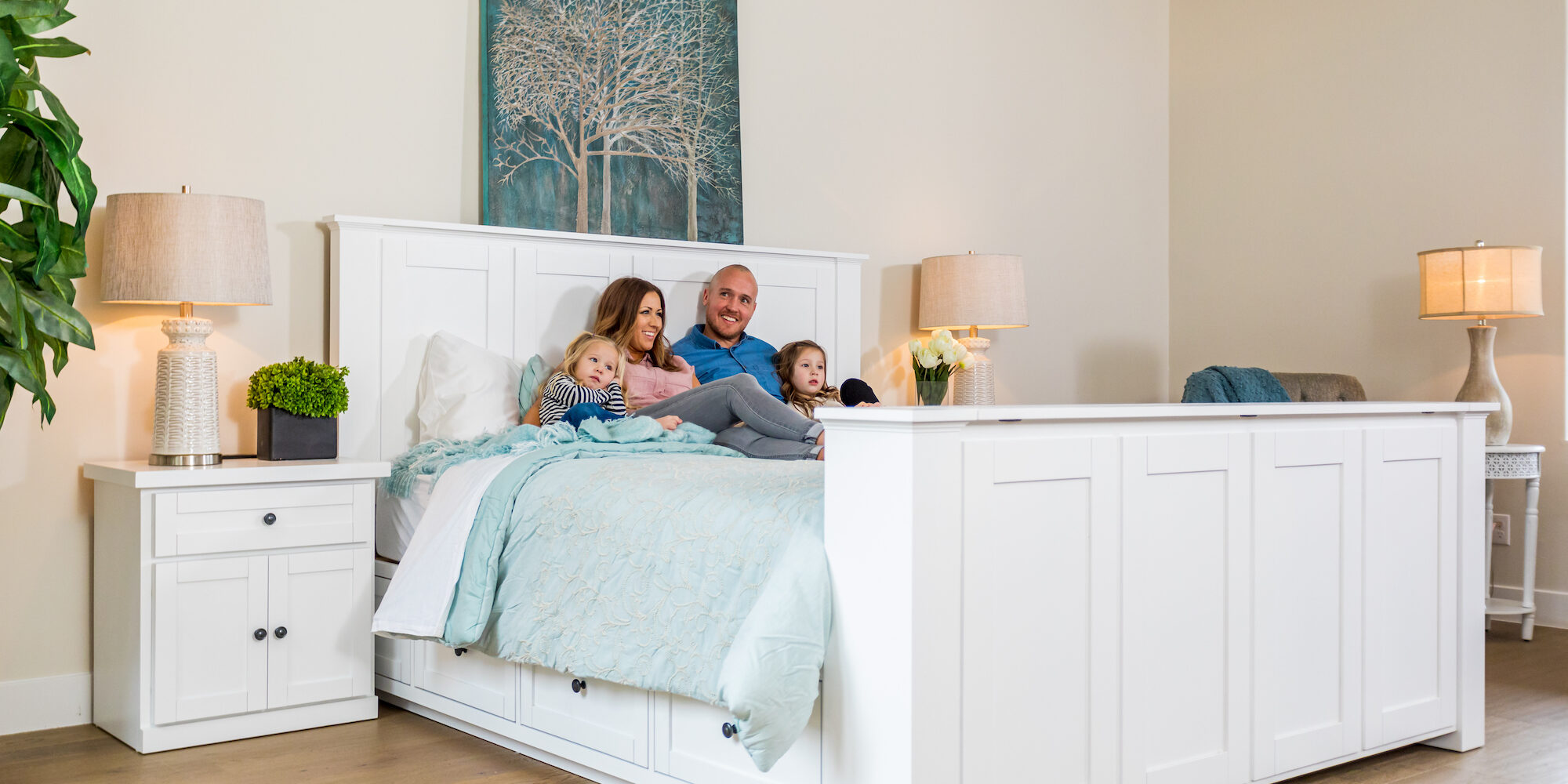 Smiling family in Hartford TV Bed family in decorated white tv lift bed