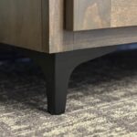 black leg of dark wood tv lift cabinet