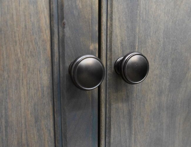 closeup on knobs of dark cabinet