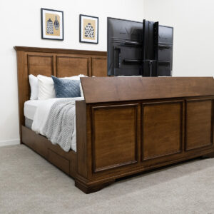 decorated dark wood bed with tv in footbed