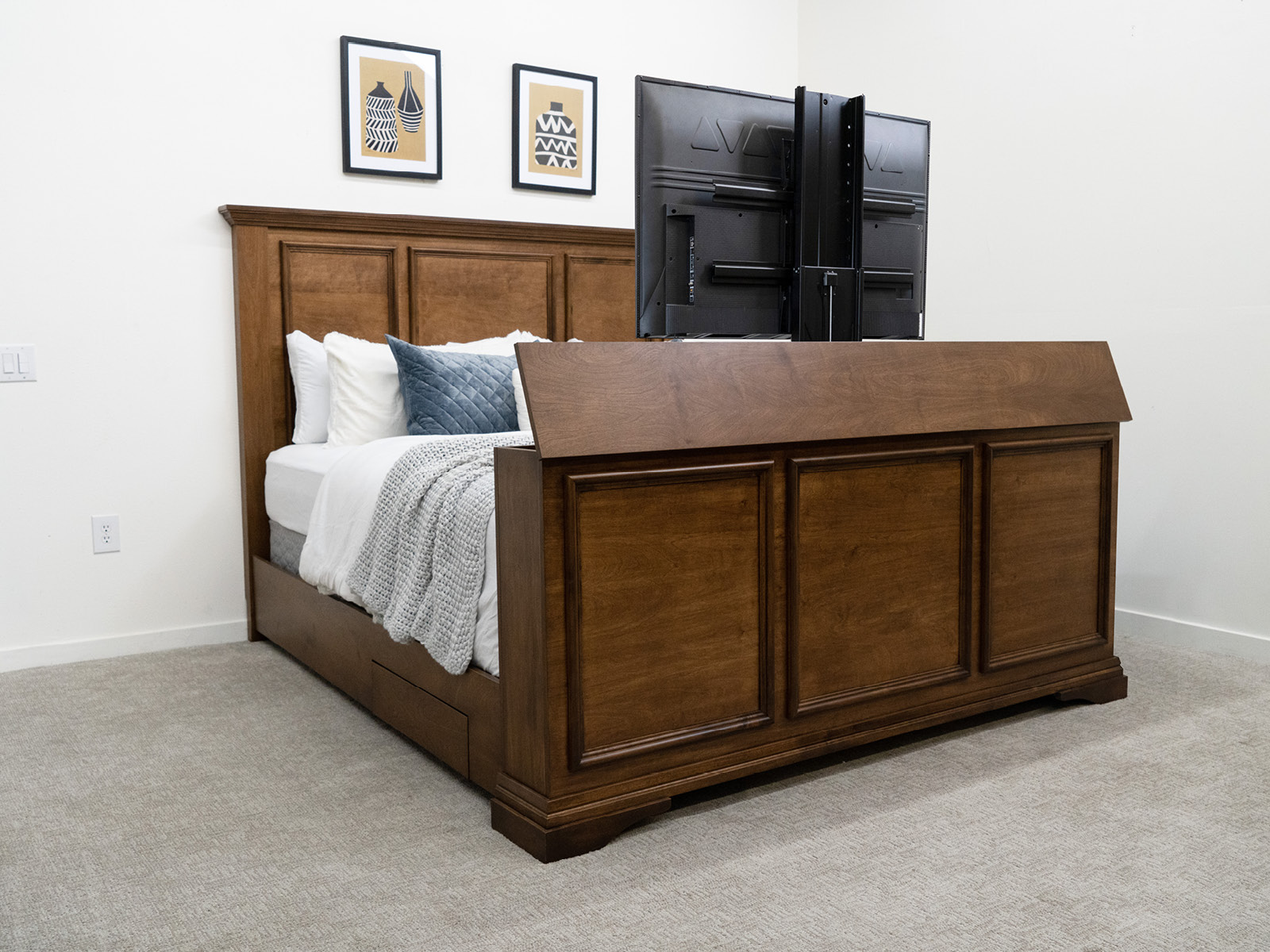 decorated dark wood bed with tv in footbed
